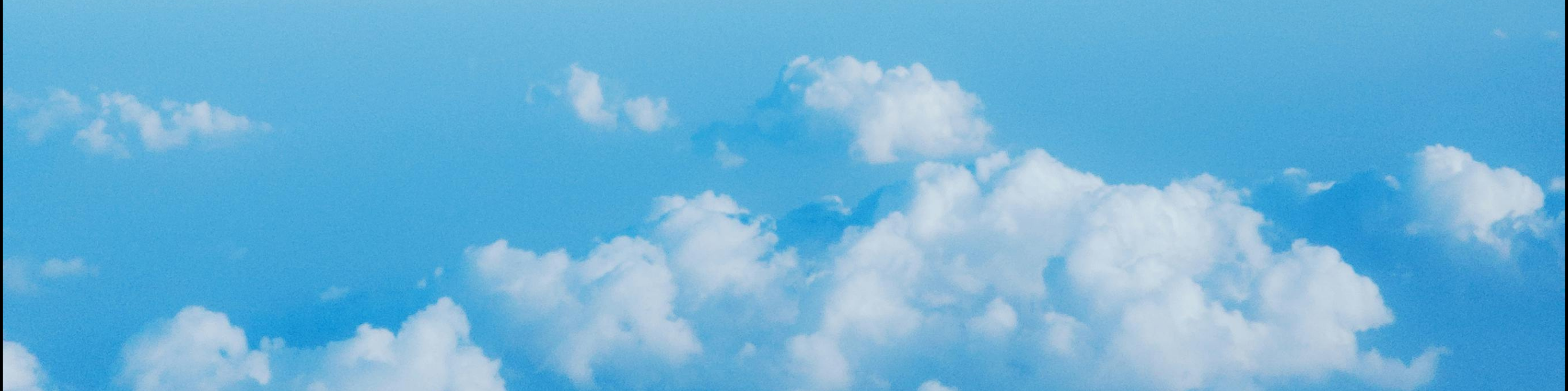 A blue sky with white clouds. There's a slight grainy effect in the image.