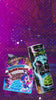 An energy drink and a bag of candy on a colorful, glittery background
